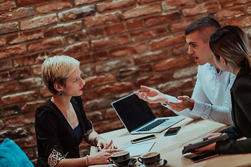 Image showing Happy businesspeople smiling cheerfully during a meeting in a coffee shop. Group of successful business professionals working as a team in a multicultural workplace.