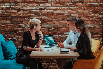 Image showing Happy businesspeople smiling cheerfully during a meeting in a coffee shop. Group of successful business professionals working as a team in a multicultural workplace.