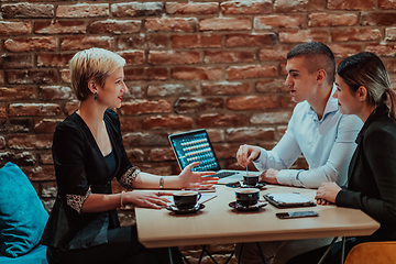 Image showing Happy businesspeople smiling cheerfully during a meeting in a coffee shop. Group of successful business professionals working as a team in a multicultural workplace.