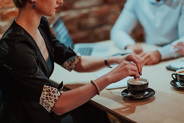 Image showing Happy businesspeople smiling cheerfully during a meeting in a coffee shop. Group of successful business professionals working as a team in a multicultural workplace.