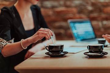 Image showing Happy businesspeople smiling cheerfully during a meeting in a coffee shop. Group of successful business professionals working as a team in a multicultural workplace.