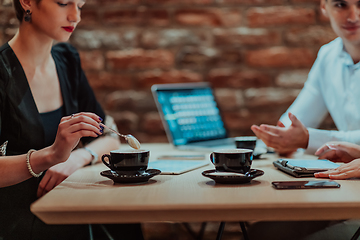 Image showing Happy businesspeople smiling cheerfully during a meeting in a coffee shop. Group of successful business professionals working as a team in a multicultural workplace.