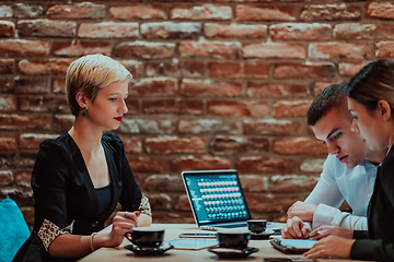 Image showing Happy businesspeople smiling cheerfully during a meeting in a coffee shop. Group of successful business professionals working as a team in a multicultural workplace.