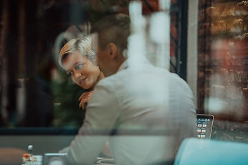 Image showing Happy businesspeople smiling cheerfully during a meeting in a coffee shop. Group of successful business professionals working as a team in a multicultural workplace.