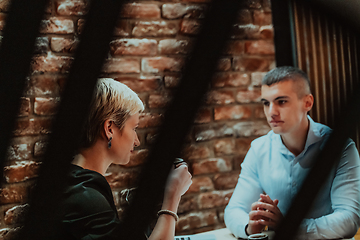 Image showing Happy businesspeople smiling cheerfully during a meeting in a coffee shop. Group of successful business professionals working as a team in a multicultural workplace.