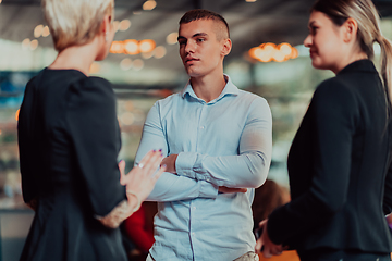 Image showing Photo of a business team of young people discussing business ideas in a modern urban environment. Selective focus