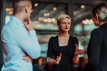 Image showing Photo of a business team of young people discussing business ideas in a modern urban environment. Selective focus