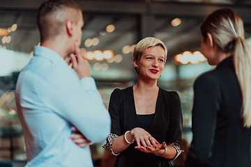 Image showing Photo of a business team of young people discussing business ideas in a modern urban environment. Selective focus