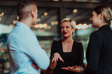 Image showing Photo of a business team of young people discussing business ideas in a modern urban environment. Selective focus