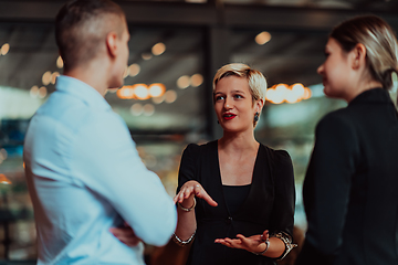 Image showing Photo of a business team of young people discussing business ideas in a modern urban environment. Selective focus