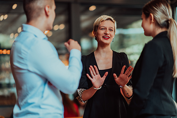 Image showing Photo of a business team of young people discussing business ideas in a modern urban environment. Selective focus