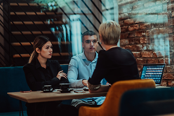 Image showing Happy businesspeople smiling cheerfully during a meeting in a coffee shop. Group of successful business professionals working as a team in a multicultural workplace.