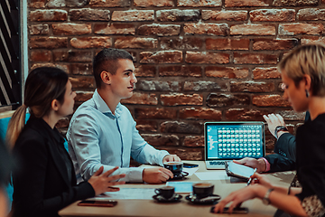 Image showing Happy businesspeople smiling cheerfully during a meeting in a coffee shop. Group of successful business professionals working as a team in a multicultural workplace.