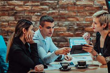 Image showing Happy businesspeople smiling cheerfully during a meeting in a coffee shop. Group of successful business professionals working as a team in a multicultural workplace.