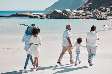 Image showing Grandparents, parents and children on beach walking to relax on summer holiday, vacation and weekend. Nature, travel and back of big family holding hands for bonding, quality time and calm by ocean