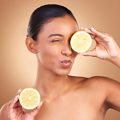 Image showing Indian woman, skincare and lemon in studio with health, wellness or fruit treatment by brown background. Asian model girl, young and happy with organic citrus fruits for health, cosmetic or skin glow