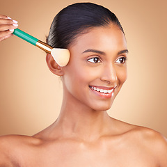 Image showing Makeup, beauty and product with indian woman and brush in studio for foundation, blush and self care. Glow, cosmetics and facial with model isolated on brown background for shine, clean or confidence