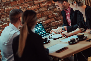 Image showing Happy businesspeople smiling cheerfully during a meeting in a coffee shop. Group of successful business professionals working as a team in a multicultural workplace.