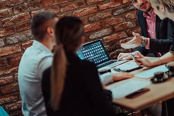 Image showing Happy businesspeople smiling cheerfully during a meeting in a coffee shop. Group of successful business professionals working as a team in a multicultural workplace.