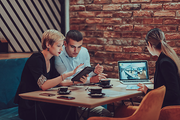 Image showing Happy businesspeople smiling cheerfully during a meeting in a coffee shop. Group of successful business professionals working as a team in a multicultural workplace.