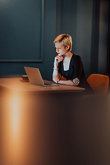 Image showing Businesswoman sitting in a cafe while focused on working on a laptop and participating in an online meetings. Selective focus.