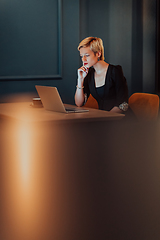 Image showing Businesswoman sitting in a cafe while focused on working on a laptop and participating in an online meetings. Selective focus.