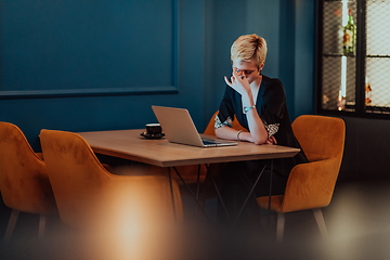 Image showing Businesswomen are stressed while working on laptop, Tired businesswoman with headache in coffee shop , feeling sick at work. Selective focus