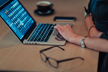 Image showing Close up photo of businesswoman sitting in a cafe while focused on working on a laptop and participating in an online meetings. Selective focus.