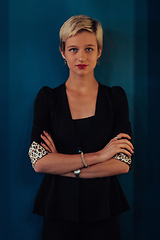 Image showing Blonde business woman, successful confidence with arms crossed on modern blue mat background. Selective focus