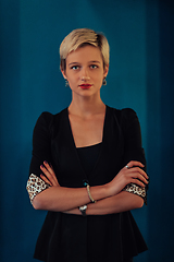 Image showing Blonde business woman, successful confidence with arms crossed on modern blue mat background. Selective focus