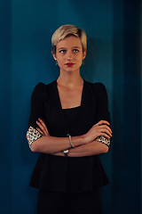 Image showing Blonde business woman, successful confidence with arms crossed on modern blue mat background. Selective focus