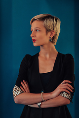 Image showing Blonde business woman, successful confidence with arms crossed on modern blue mat background. Selective focus