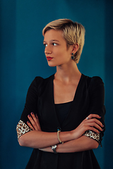 Image showing Blonde business woman, successful confidence with arms crossed on modern blue mat background. Selective focus