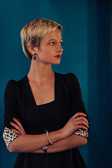 Image showing Blonde business woman, successful confidence with arms crossed on modern blue mat background. Selective focus