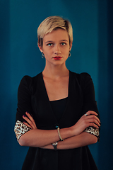 Image showing Blonde business woman, successful confidence with arms crossed on modern blue mat background. Selective focus