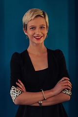 Image showing Blonde business woman, successful confidence with arms crossed on modern blue mat background. Selective focus