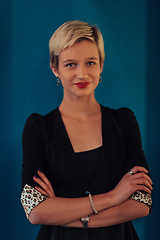 Image showing Blonde business woman, successful confidence with arms crossed on modern blue mat background. Selective focus