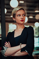Image showing Business woman in a black suit, successful confidence with arms crossed in modern office