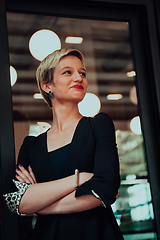 Image showing Business woman in a black suit, successful confidence with arms crossed in modern office