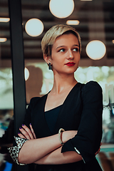 Image showing Business woman in a black suit, successful confidence with arms crossed in modern office