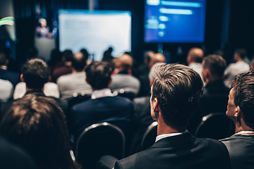 Image showing Speaker giving a talk in conference hall at business event. Rear view of unrecognizable people in audience at the conference hall. Business and entrepreneurship concept.