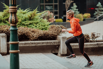 Image showing A blonde in a sports outfit is running around the city in an urban environment. The hot blonde maintains a healthy lifestyle.