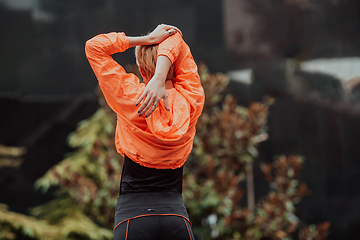 Image showing Fit attractive woman in sportswear stretching before jogging. Workout, sport, activity, fitness, vacation and training concept.