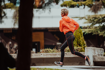 Image showing A blonde in a sports outfit is running around the city in an urban environment. The hot blonde maintains a healthy lifestyle.