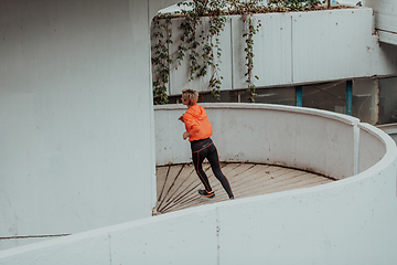 Image showing Women in sports clothes running in a modern urban environment. The concept of a sporty and healthy lifestyle