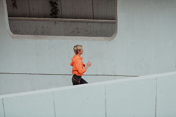 Image showing Women in sports clothes running in a modern urban environment. The concept of a sporty and healthy lifestyle