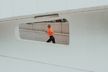 Image showing Women in sports clothes running in a modern urban environment. The concept of a sporty and healthy lifestyle