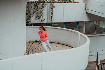 Image showing Women in sports clothes running in a modern urban environment. The concept of a sporty and healthy lifestyle