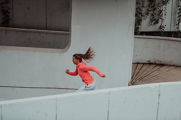 Image showing Women in sports clothes running in a modern urban environment. The concept of a sporty and healthy lifestyle