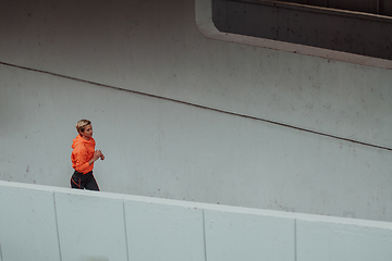 Image showing Women in sports clothes running in a modern urban environment. The concept of a sporty and healthy lifestyle